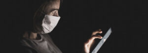 Woman with mask using ipad